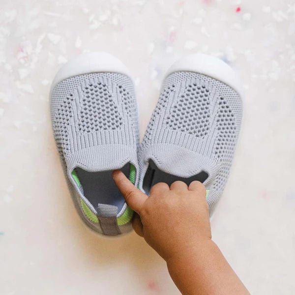 Baby wearing gray mesh sneakers showing flexible fit